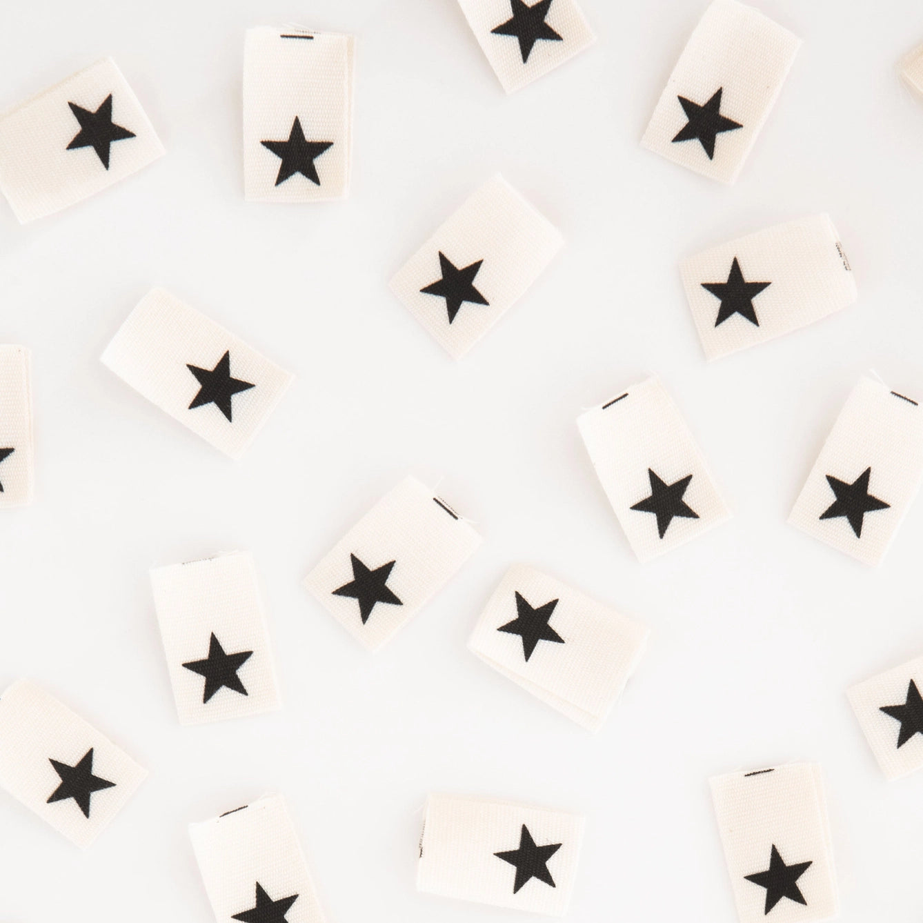 White tiles with black star patterns arranged randomly on a light gray background