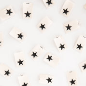 White tiles with black star patterns arranged randomly on a light gray background