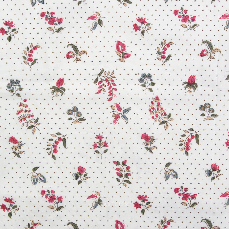Floral pattern fabric with red flowers and green leaves on a white background with black dots