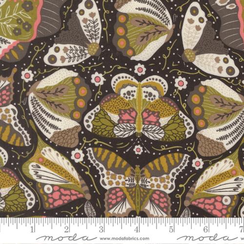 image of fabric with multicolored moths and small pink and white colored flowers on a black background with a ruler at the bottom.