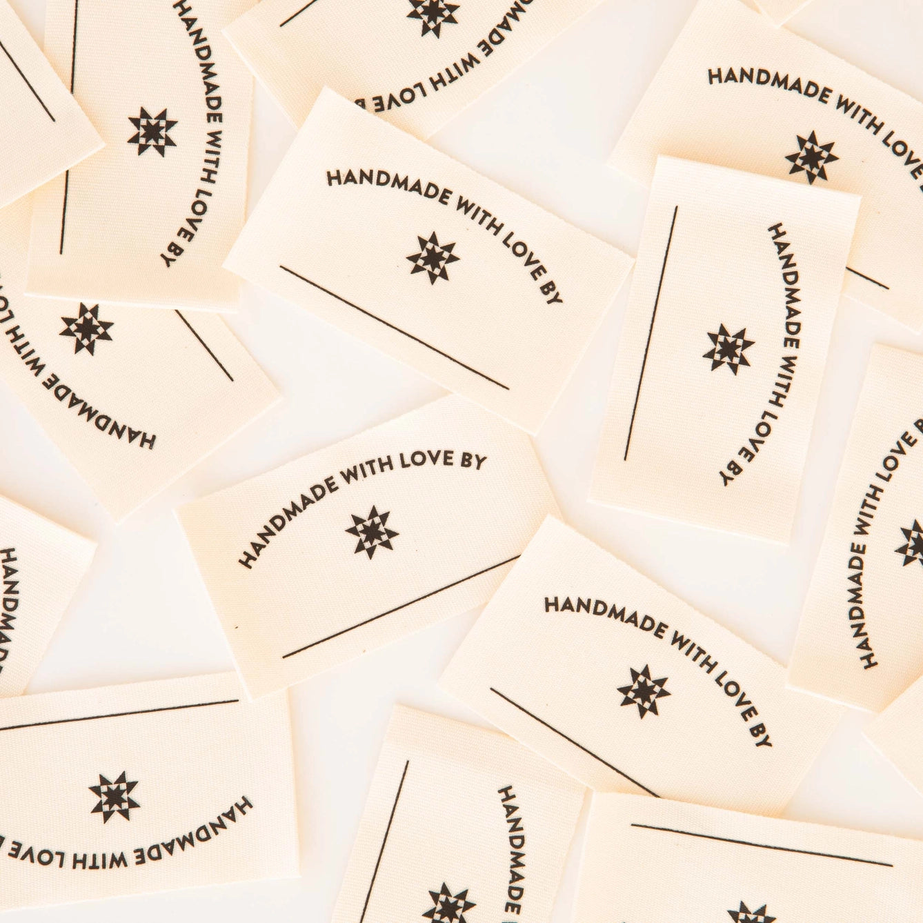 Multiple 'Handmade with Love' labels scattered on a light background