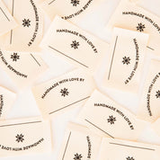 Multiple 'Handmade with Love' labels scattered on a light background