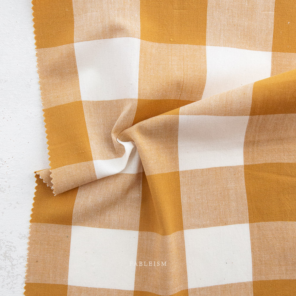 Checkered fabric with yellow and beige squares on a white background