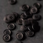 Dark brown buttons scattered on a dark gray background