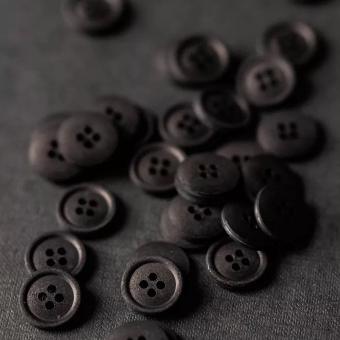 Dark brown buttons scattered on a dark gray background