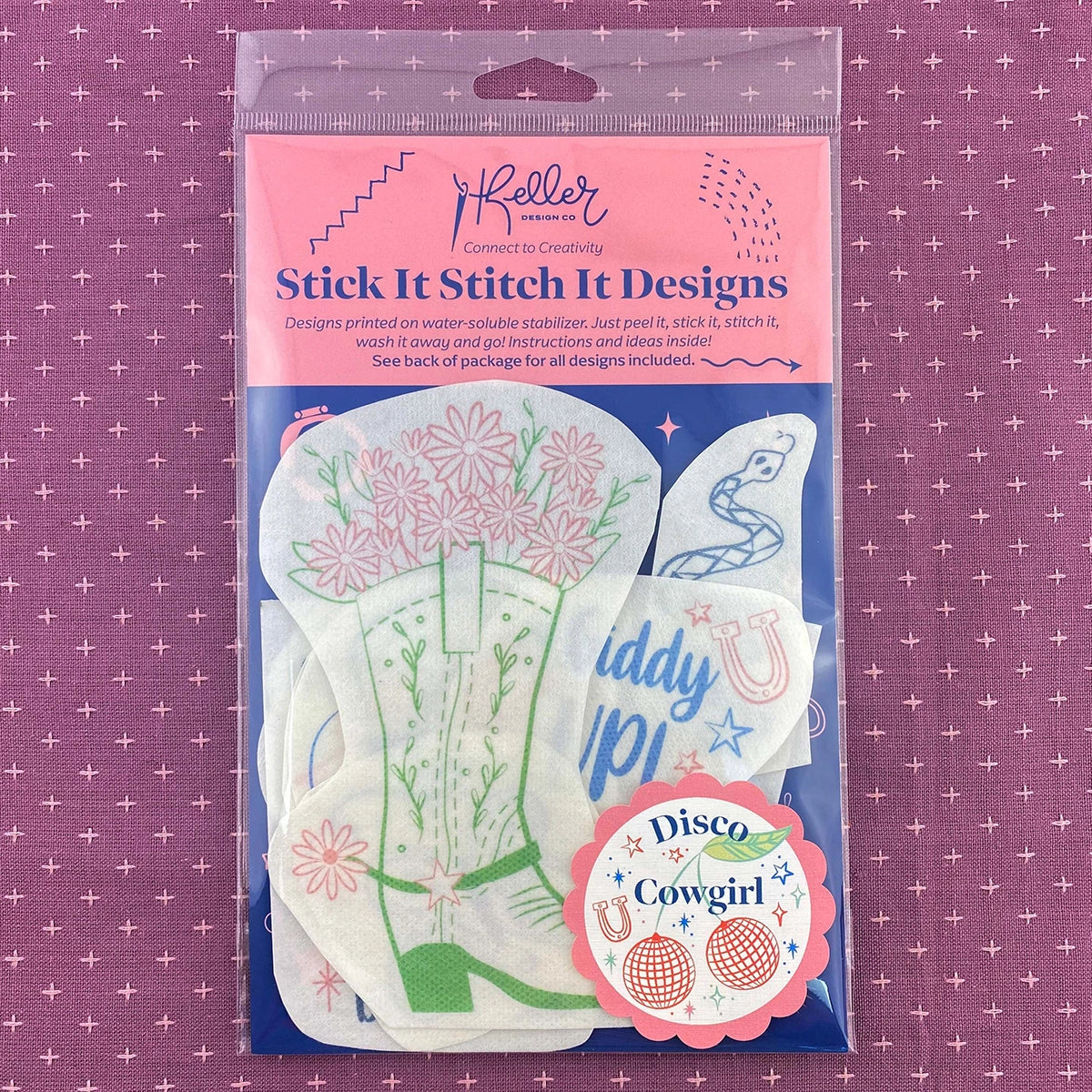 Packaged product with 'Stick It Stitch It Designs' on a pink and purple patterned background