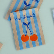 Handmade labels with cherry design on a light blue background