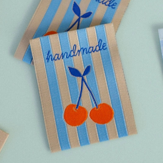 Handmade labels with cherry design on a light blue background