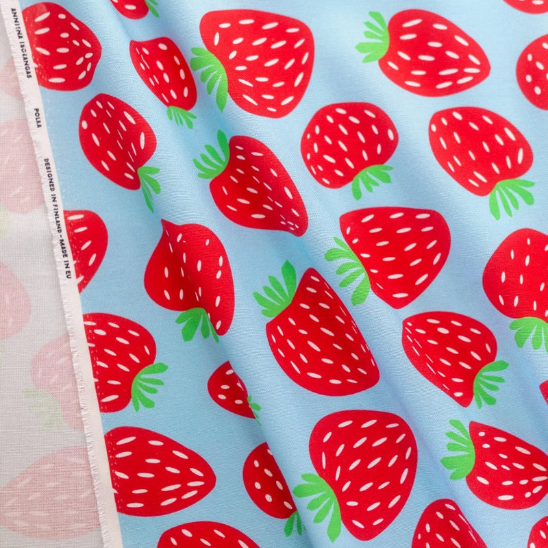 Fabric with red strawberry pattern on a blue background