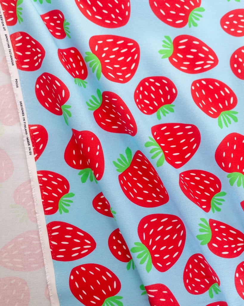Fabric with red strawberry pattern on a blue background