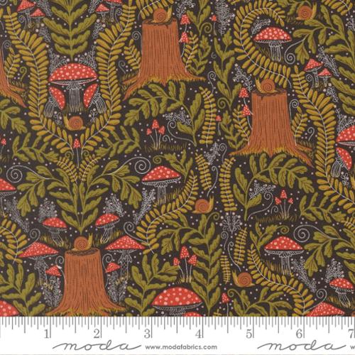 Fabric with green leaves, red mushrooms, and tree stumps with snails on them, on a black background with a ruler at the bottom.