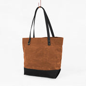 Brown tote bag with black accents on a white background