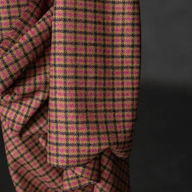 Close-up of a pink and black checkered fabric against a dark background