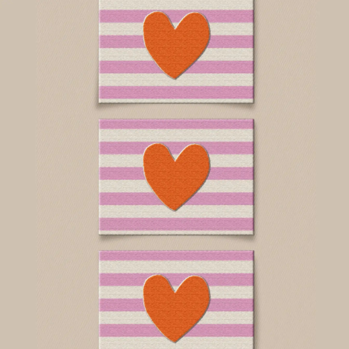 Three sewing labels with a red heart on a background of pink and white stripes.